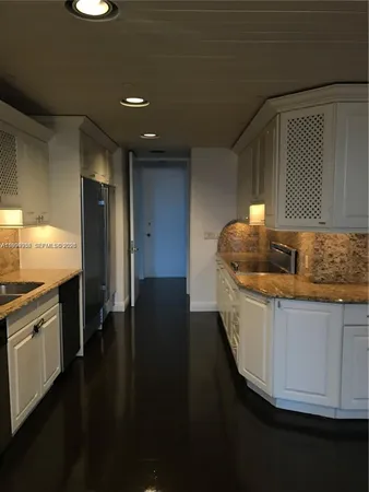 a kitchen with granite countertop a sink and cabinets
