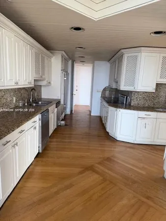 a kitchen with granite countertop a sink and cabinets