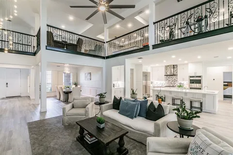 a living room with furniture kitchen view and a chandelier