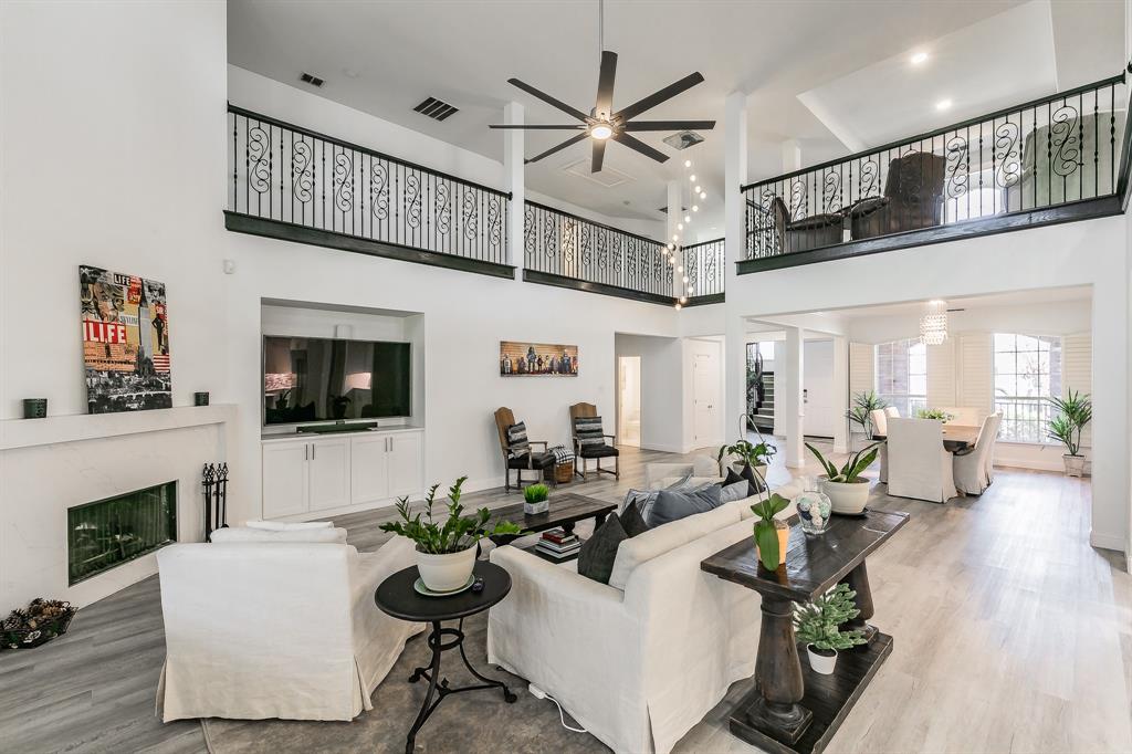12548 Avondale Ridge Drive Fort Worth, TX 76179 - Photo 13 of 40 Living area with visible vents, a fireplace, a towering ceiling, and wood finished floors