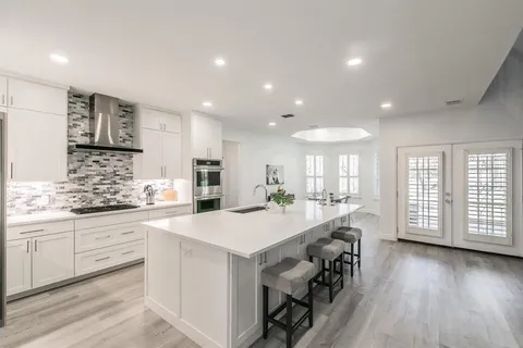 a kitchen with a sink a stove a refrigerator and cabinets