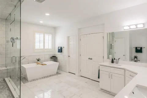 a bathroom with a double vanity sink mirror and bathtub
