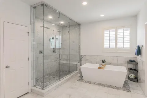 a bathroom with a tub shower sink and mirror