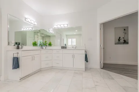 a spacious bathroom with a granite countertop sink a mirror and a