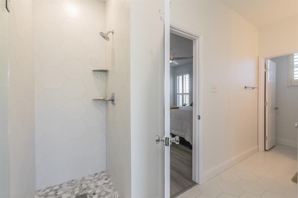12548 Avondale Ridge Drive Fort Worth, TX 76179 - Photo 25 of 40 Ensuite bathroom to first floor bedroom featuring a ceiling fan, baseboards, a tile shower, and connected bathroom