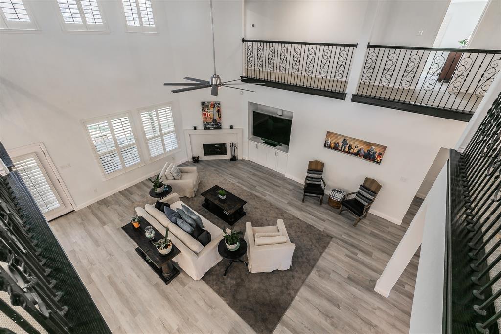 12548 Avondale Ridge Drive Fort Worth, TX 76179 - Photo 29 of 40 Living area featuring ceiling fan, baseboards, a towering ceiling, and wood finished floors