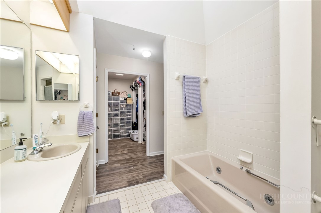 939 Don Bare Road Jefferson, NC 28640 - Photo 18 of 49 a bathroom with a tub a sink and a large mirror
