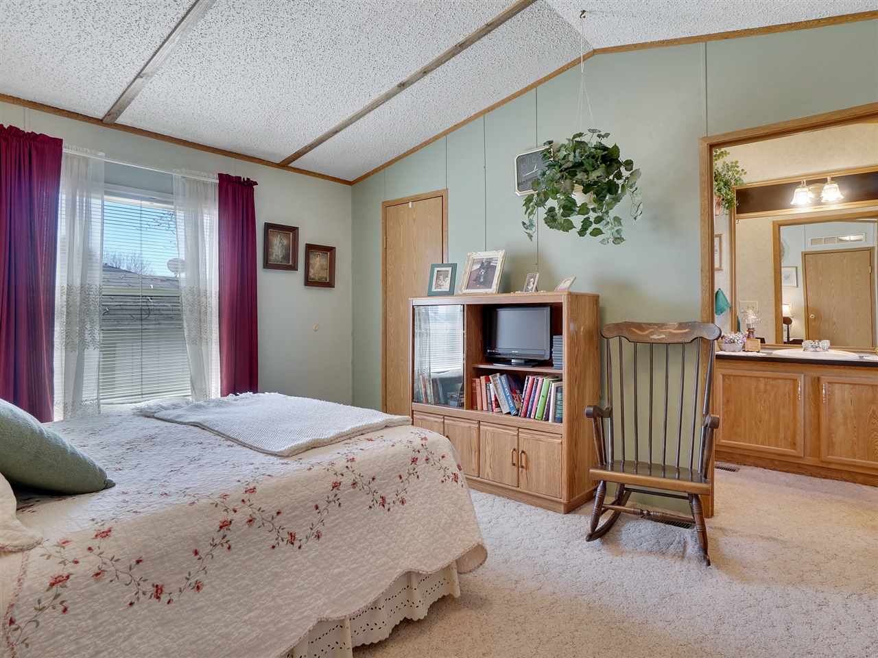 435 32 Road, Unit 705 Clifton, CO 81520 - Photo 9 of 16 a bedroom with a bed a flat screen tv and a large window