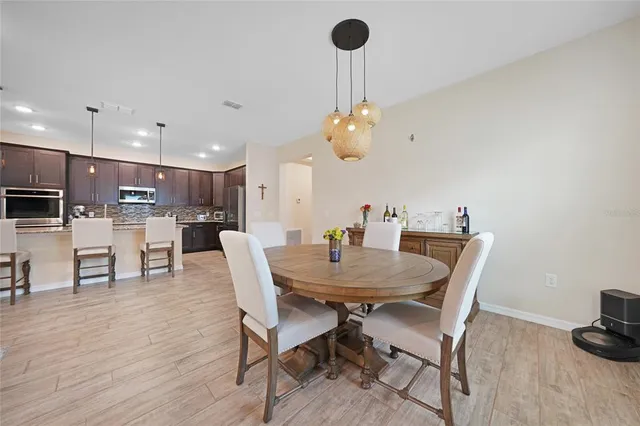 a dining room with furniture a chandelier and wooden floor
