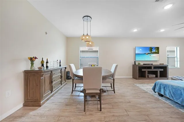 a living room with furniture a flat screen tv and kitchen view