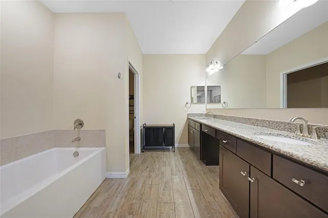 a spacious bathroom with a double vanity sink a mirror and a shower