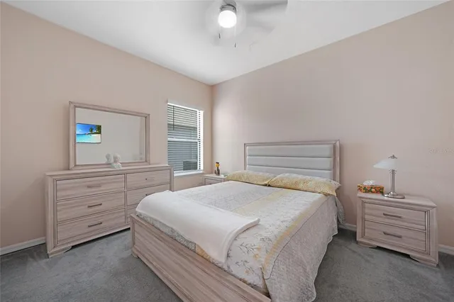 a bedroom with a bed and a lamp on the dresser