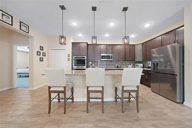 a kitchen with a refrigerator a dining table and chairs