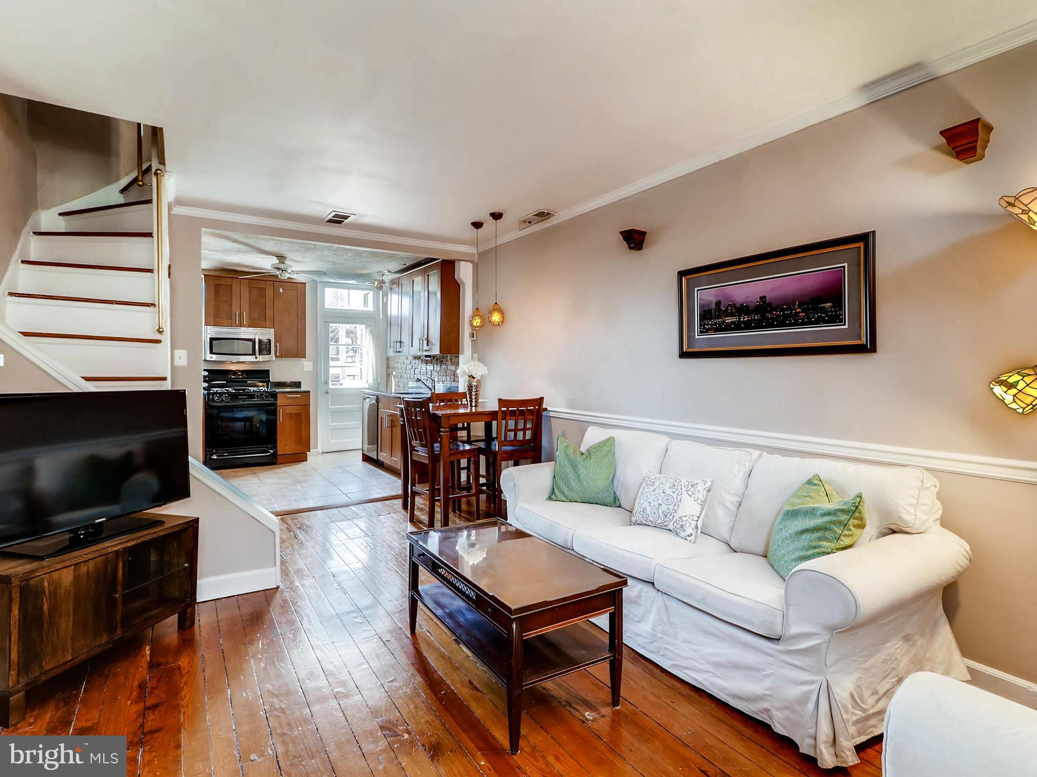 1212 Riverside Avenue Baltimore, MD 21230 - Photo 5 of 27 a living room with furniture a flat screen tv and kitchen view
