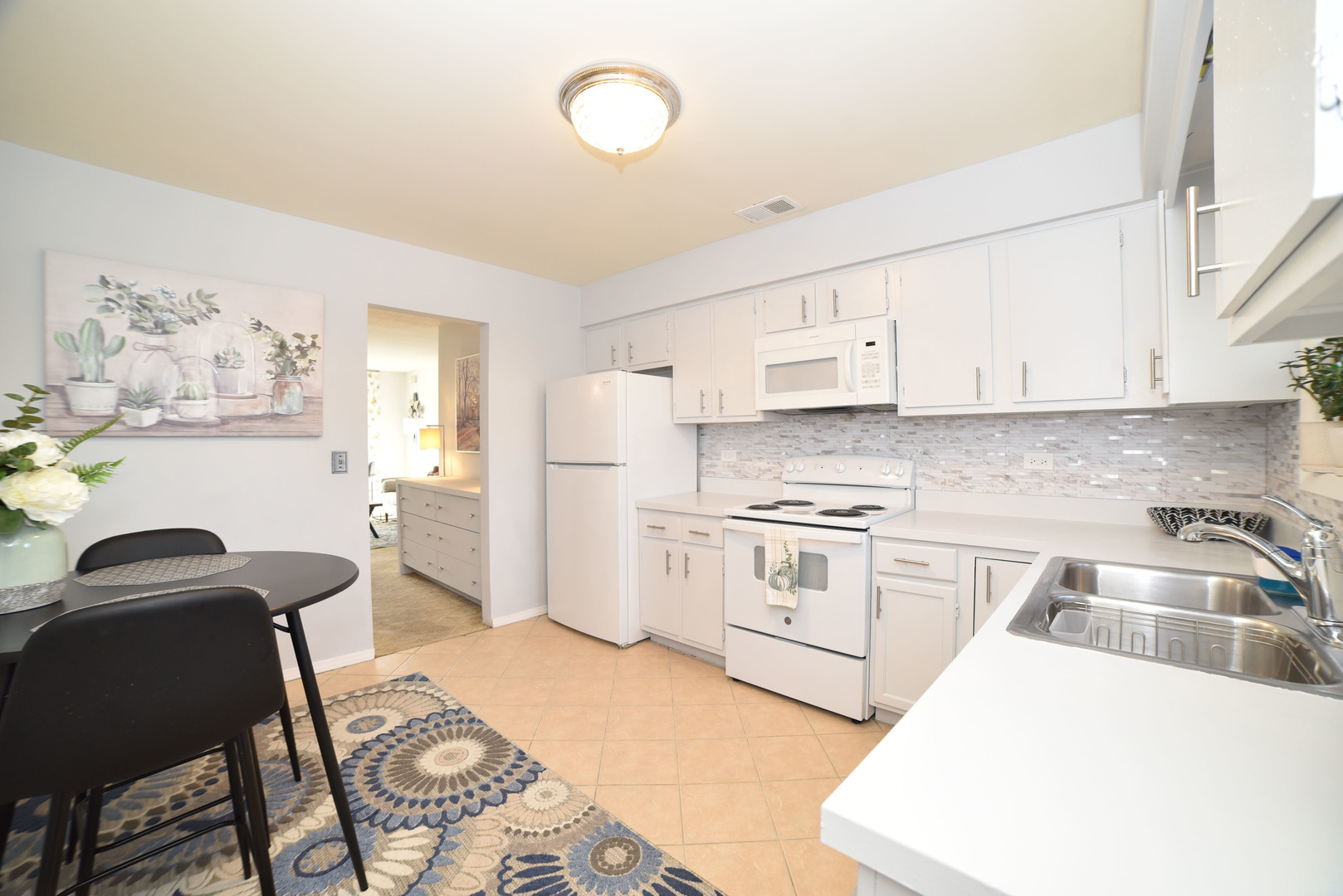 704 Cobblestone Circle, Unit 3E Glenview, IL 60025 - Photo 11 of 21 a kitchen with granite countertop a sink stove and white cabinets