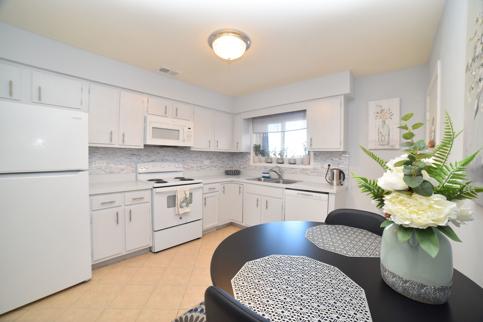 704 Cobblestone Circle, Unit 3E Glenview, IL 60025 - Photo 12 of 21 a kitchen with stainless steel appliances kitchen island granite countertop a refrigerator a sink a stove a dining table and chairs