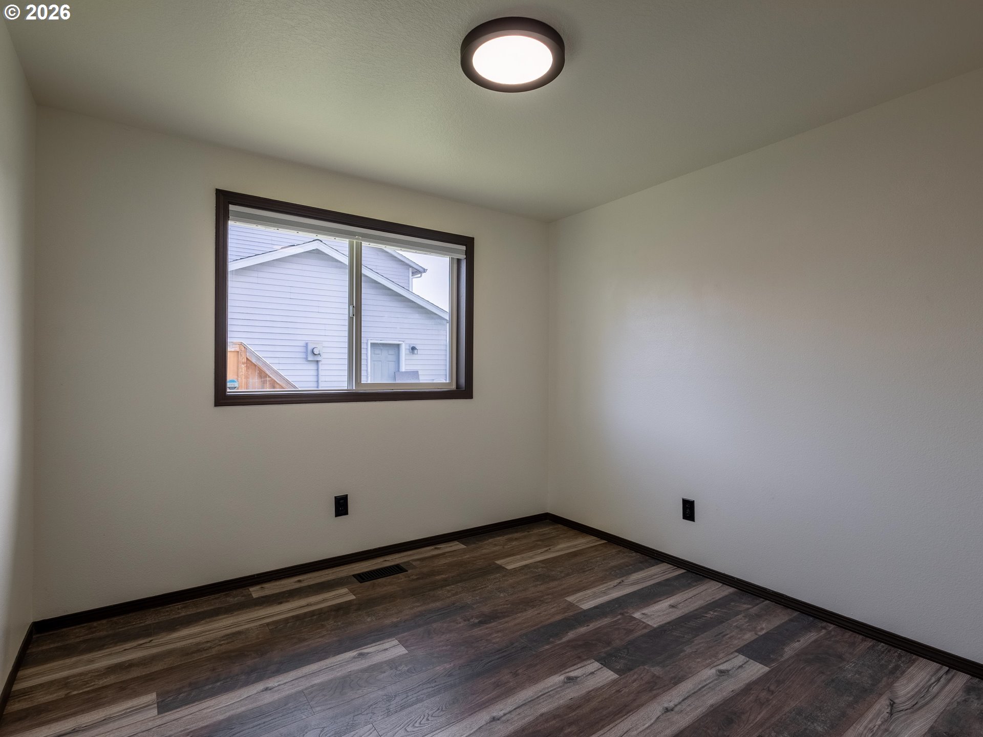 304 East Wilson Street Yacolt, WA 98675 - Photo 16 of 29 an empty room with wooden floor and windows