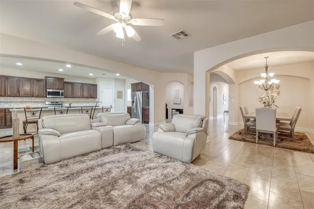 a living room with furniture and a view of kitchen
