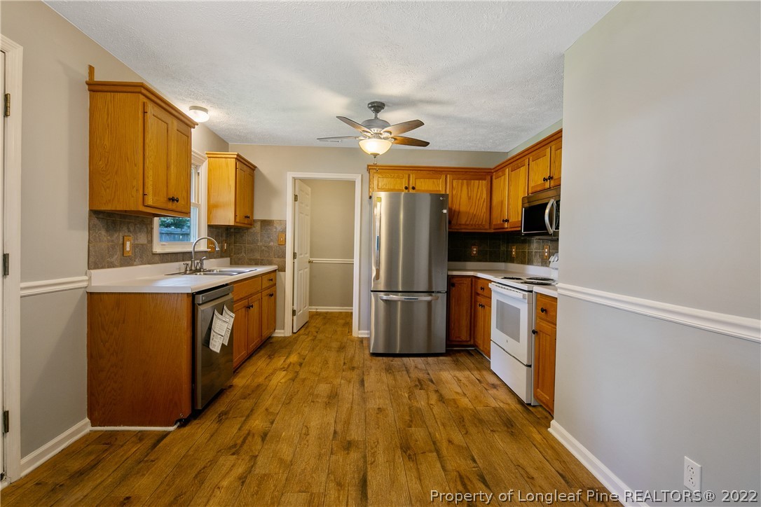 203 Cobblestone Court Raeford, NC 28376 - Photo 12 of 46 a kitchen with a refrigerator a stove top oven a sink and dishwasher