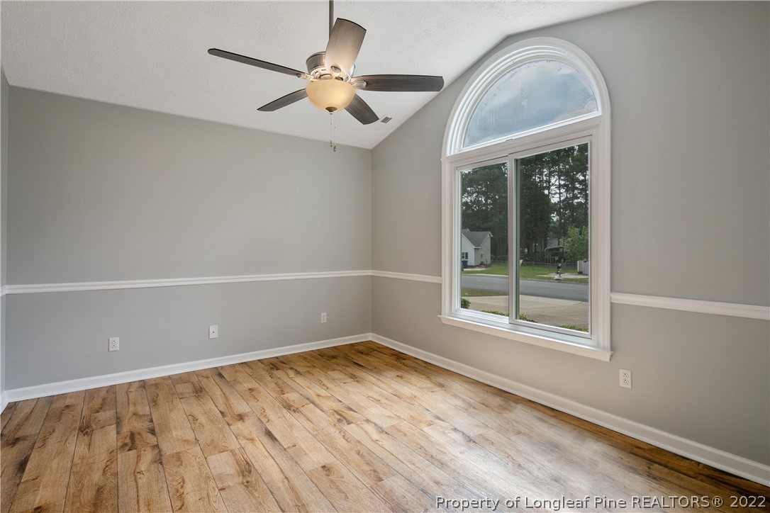 203 Cobblestone Court Raeford, NC 28376 - Photo 21 of 46 an empty room with a chandelier fan and windows