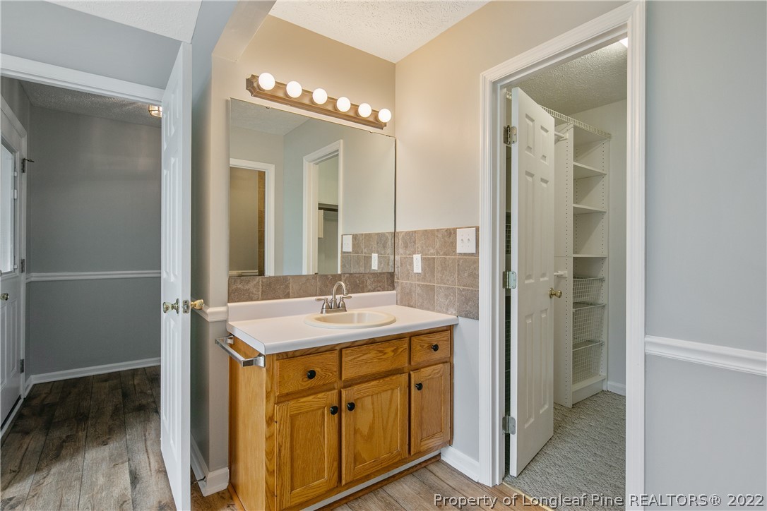 203 Cobblestone Court Raeford, NC 28376 - Photo 26 of 46 a bathroom with a granite countertop sink a mirror and a shower