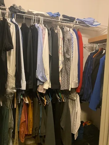 a view of walk in closet with clothes and shoes