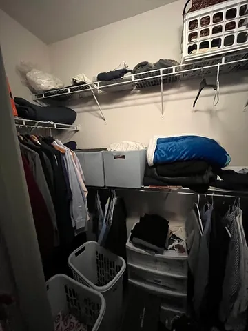 a view of walk in closet with clothes and shoes