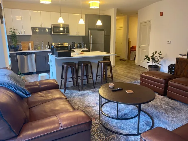 a living room with furniture a kitchen view and a kitchen view