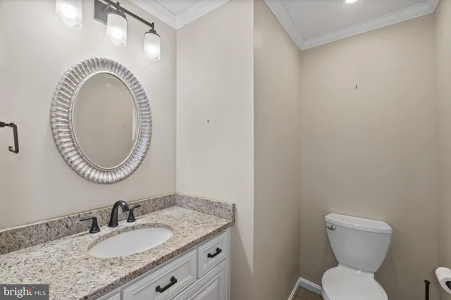 a bathroom with a granite countertop toilet a sink and a mirror