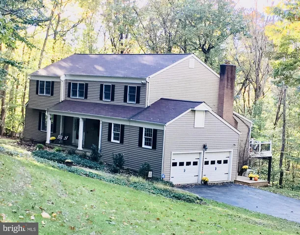 a aerial view of a house with table and chairs in a yard