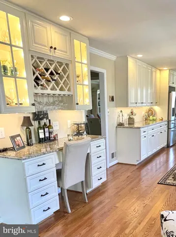 a kitchen with granite countertop a sink cabinets stainless steel appliances and a window