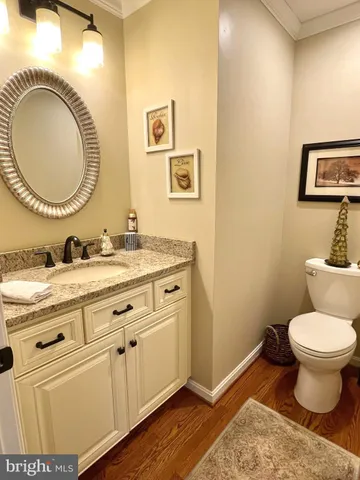 a bathroom with a granite countertop toilet a sink and a mirror