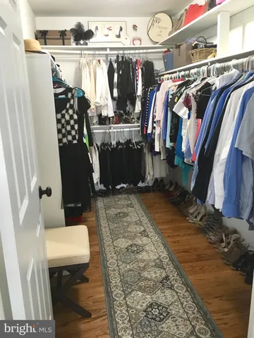 a view of walk in closet with clothes and shoes
