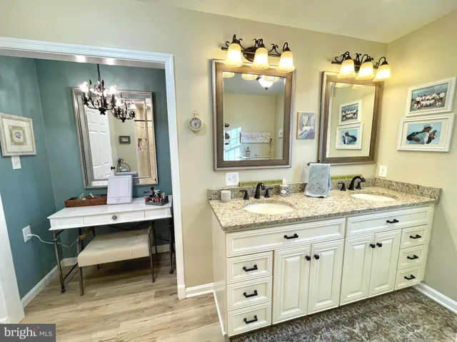 a en suite bathroom with a granite countertop sink and a mirror
