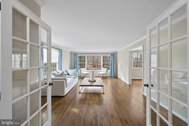 a living room with furniture large window and wooden floor