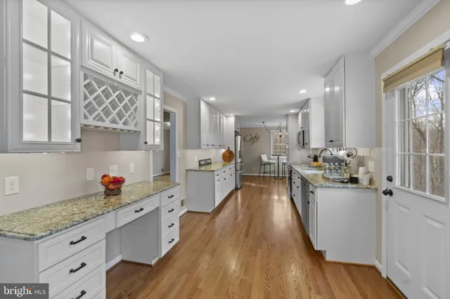 a kitchen with stainless steel appliances granite countertop lots of counter top space and wooden floor
