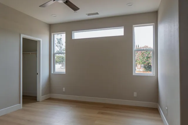 an empty room with windows and closet