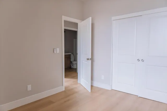 an empty room with wooden floor and closet