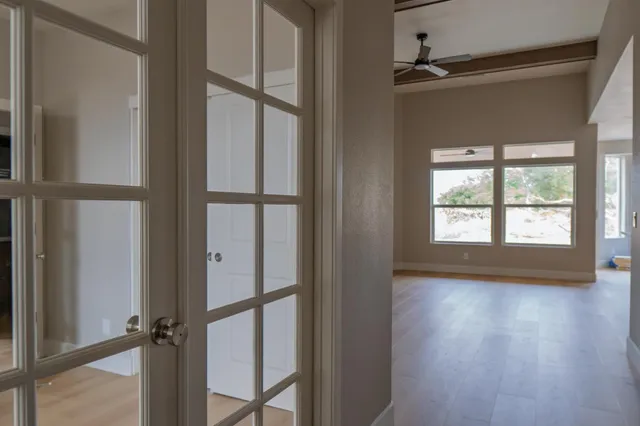 a view of a hardwood floor and windows in a room
