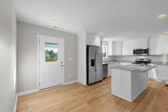 a kitchen with stainless steel appliances a refrigerator stove and microwave