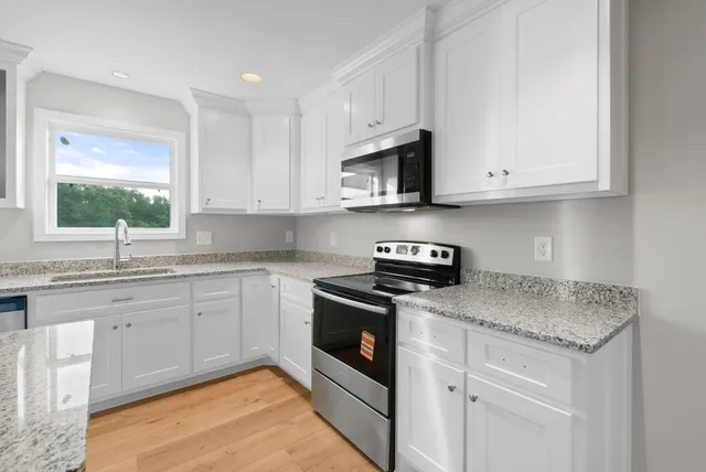 a kitchen with stainless steel appliances granite countertop a sink and a stove