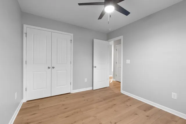 a view of an empty room and chandelier fan