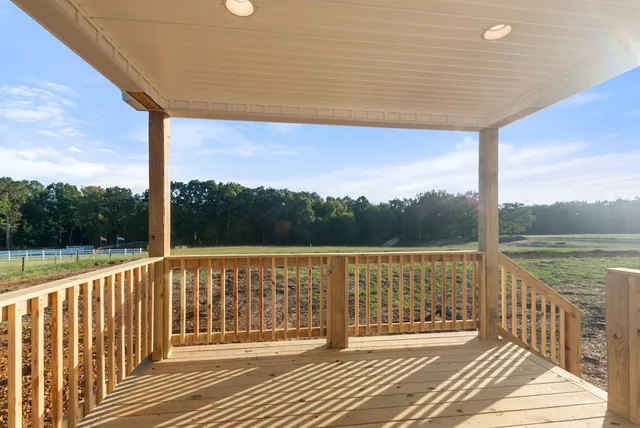 a view of a balcony with wooden floor next to a yard