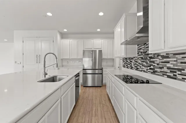a kitchen with kitchen island stainless steel appliances a sink a stove and a refrigerator