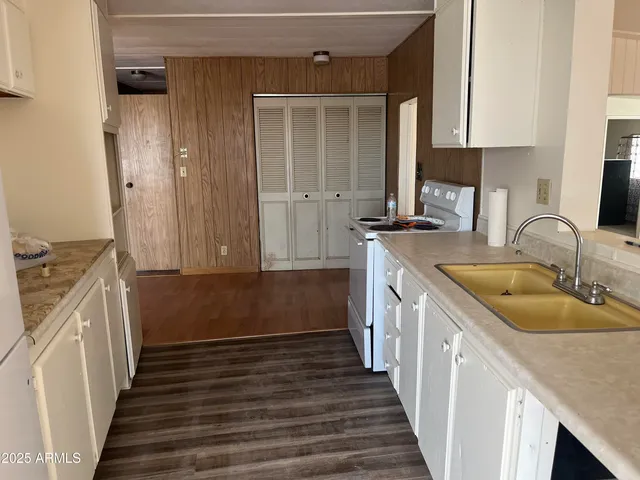 a kitchen with granite countertop a sink stove and cabinets