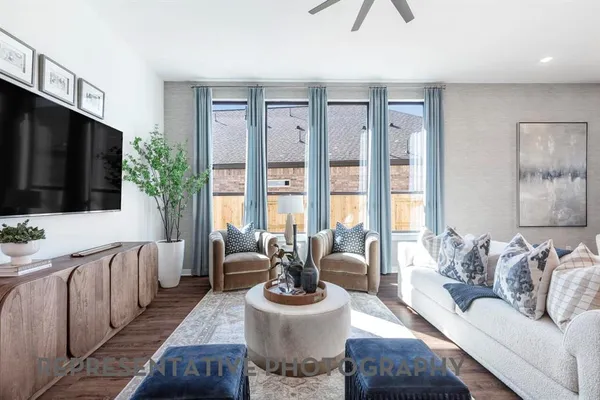 a living room with furniture a flat screen tv and a large window