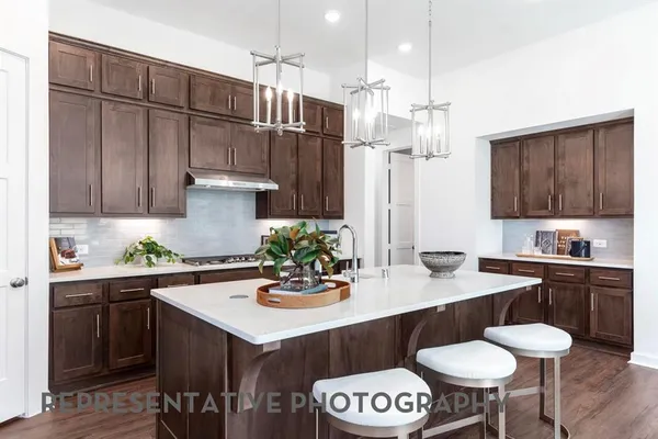 a kitchen with a sink a stove and wooden cabinets