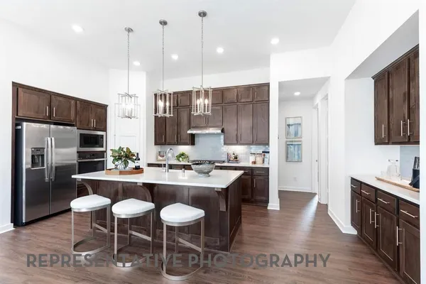 a kitchen with kitchen island granite countertop a sink and wooden cabinets
