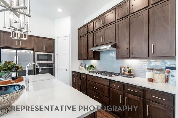 a kitchen with stainless steel appliances a sink a stove and cabinets