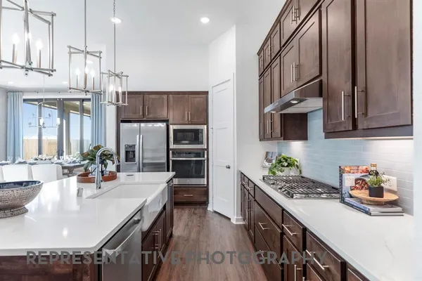a kitchen with stainless steel appliances kitchen island granite countertop a lot of counter space and wooden floor